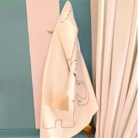 Hooded baby towel with embroidered elephant hanging in a nursery